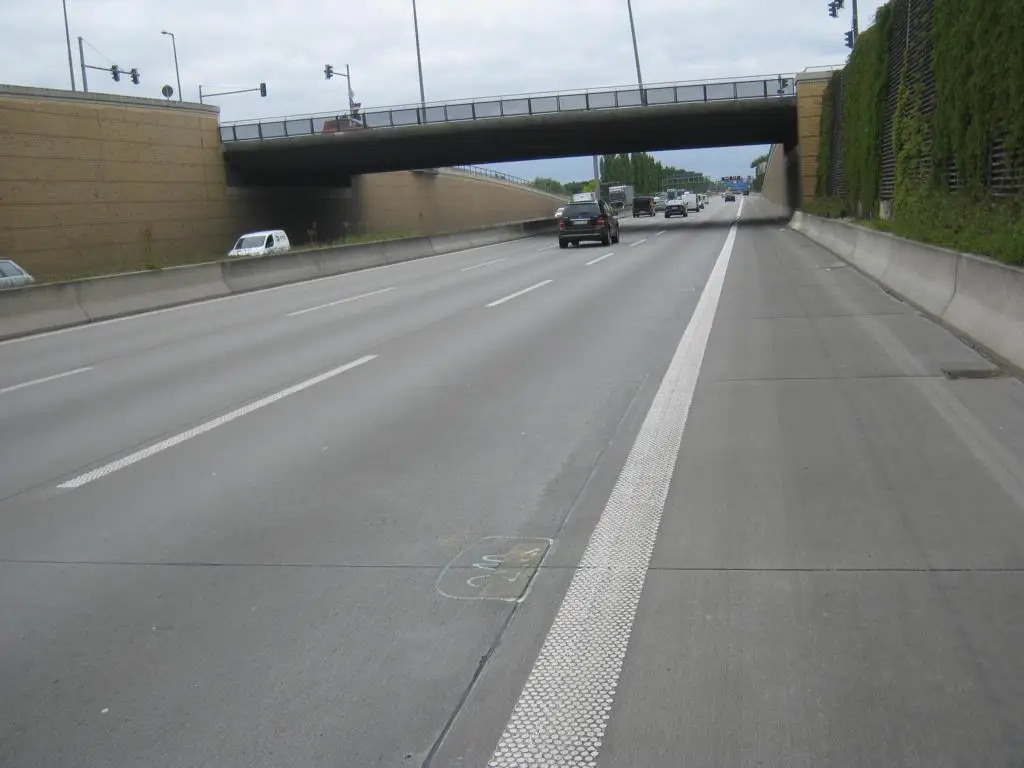 Bundesautobahn A113 mit Fahrbahn, Überführung und Verkehr, dargestellt als Referenzprojekt von PEBA GmbH für Bauqualität und Infrastrukturprüfungen.